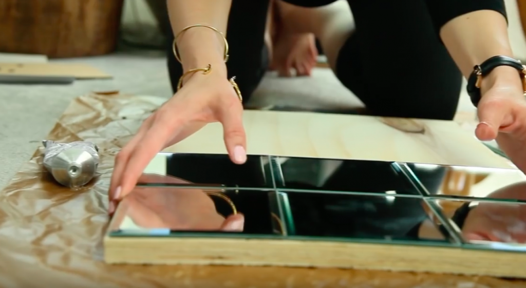 She Is Gluing Mirrors From The Dollar Store Onto Plywood To Make A